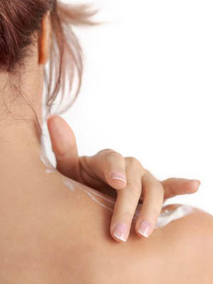 Uma mulher aplicando cuidados OTC no ombro